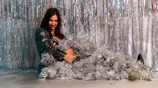 Stüdyoda poz veren parlak noel süsleriyle güzel seksi kadın, tatil konsepti.   