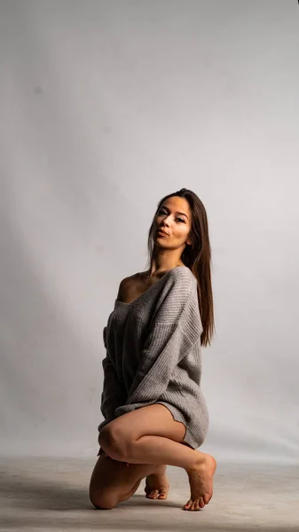 Hermosa chica sexy, con vestido gris, fondo blanco. — Foto de Stock