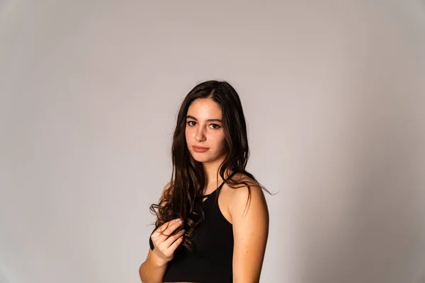 Portrait of disconcerted young woman in light clothes looking aside covering nose with hand isolated on white wall background in studio. People sincere emotions, lifestyle concept. Mock up copy space — Stock Photo, Image