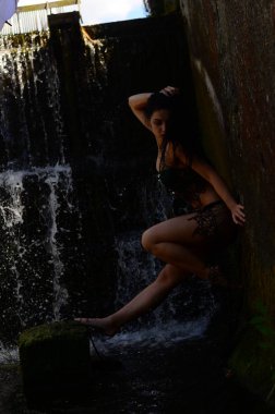 Genç esmer model bir şelale karşı poz