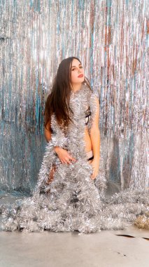 Stüdyoda poz veren parlak noel süsleriyle güzel seksi kadın, tatil konsepti.   