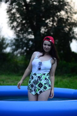 Gün batımında, havuzda ıslak güzel bir kız bedeni..