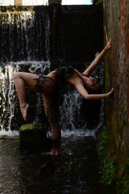 Genç esmer model bir şelale karşı poz