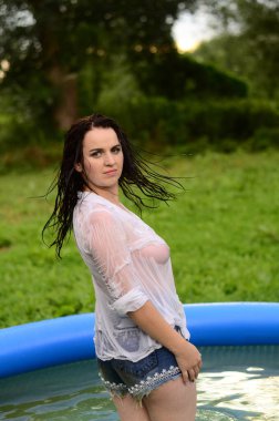 Gün batımında, havuzda ıslak güzel bir kız bedeni.