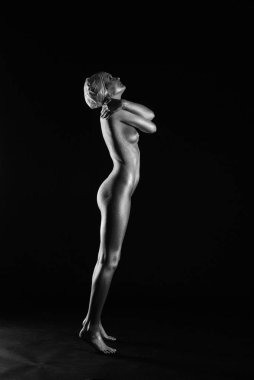 Gümüş rengi vücut boyalı genç atletik kadın.