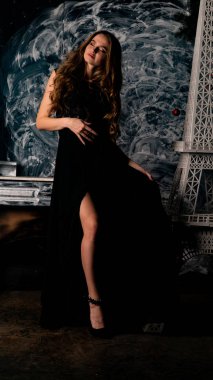 Stüdyoda poz veren narin siyah elbiseli kadın.  