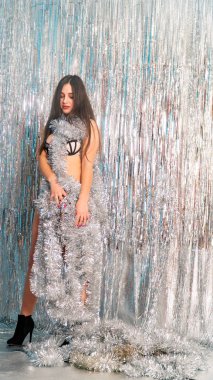 Stüdyoda poz veren parlak noel süsleriyle güzel seksi kadın, tatil konsepti.   