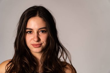 Açık renk elbiseli endişeli genç bir kadının portresi. Stüdyonun beyaz arka planında, elleri izole bir şekilde burnunu kapatıyor. İnsanlar samimi duygular, yaşam tarzı konsepti. Kopyalama alanı oluştur