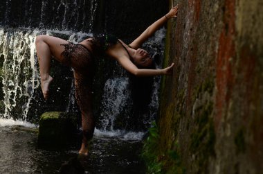 Genç esmer model bir şelale karşı poz