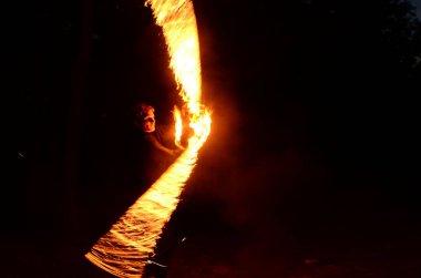 Usta fakir karanlıkta ateş gösterisi sırasında alevlerle gösteri yapıyor..