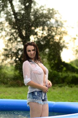 Gün batımında, havuzda ıslak güzel bir kız bedeni..