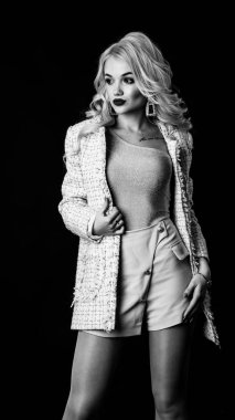 Güzel, şık, sarışın, makyajlı, siyah arka planda saç kesimi olan bir kadın.  