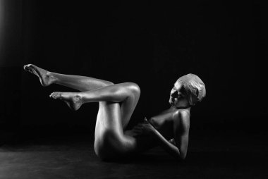 Gümüş rengi vücut boyalı genç atletik kadın.