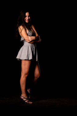 Seksi, güzel, esmer, esmer bir kadın. Kıyafet şortu ve ceket makyajı giyiyor. Ofis tarzı şık bir iş kadını. Resmi elbise. Dalgalı saçlı, çekici bir kız.