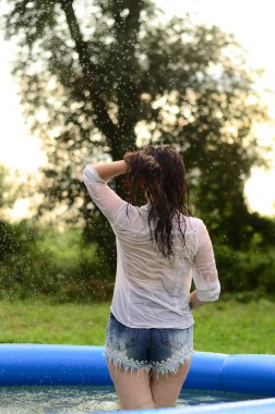 Gün batımında, havuzda ıslak güzel bir kız bedeni..