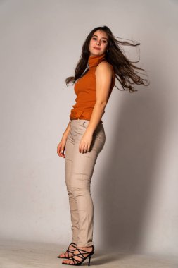 Güzel esmer model, karanlık odada poz veriyor. 