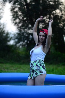 Gün batımında, havuzda ıslak güzel bir kız bedeni..