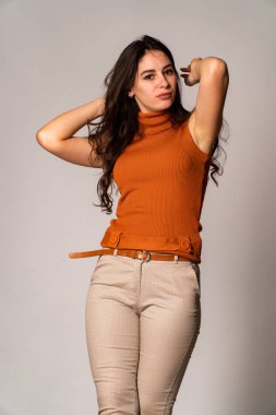 Güzel esmer model, karanlık odada poz veriyor. 