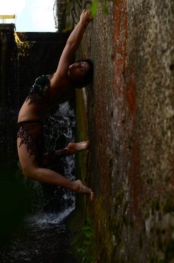 Genç esmer model bir şelale karşı poz