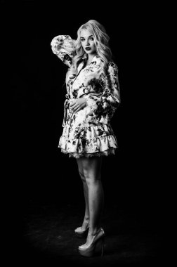 Güzel, şık, sarışın, makyajlı, siyah arka planda saç kesimi olan bir kadın.  