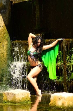 Genç esmer model bir şelale karşı poz