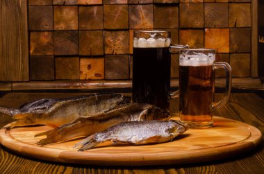 Bira bardağı, arka planda kurutulmuş balık, ahşap bir masada, kırsal bir tarzda..
