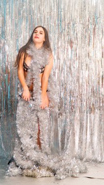 Stüdyoda poz veren parlak noel süsleriyle güzel seksi kadın, tatil konsepti.   