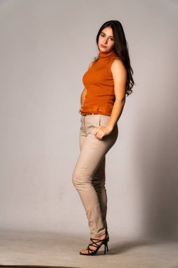 Güzel esmer model, karanlık odada poz veriyor. 