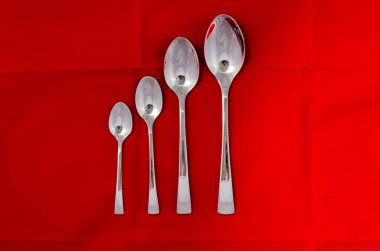 Tekstil arka planına karşı gümüş metal kaşıklar 
