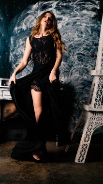 Stüdyoda dantel elbiseyle poz veren genç ve güzel bayan.  