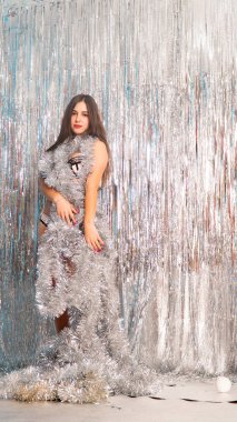 Stüdyoda poz veren parlak noel süsleriyle güzel seksi kadın, tatil konsepti.   