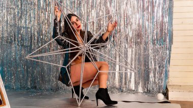 Stüdyoda poz veren parlak noel süsleriyle güzel seksi kız, tatil konsepti.  