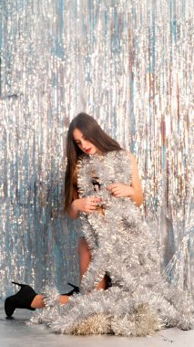 Stüdyoda poz veren parlak noel süsleriyle güzel seksi kadın, tatil konsepti.   