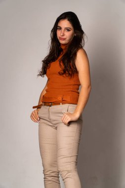 Güzel esmer model, karanlık odada poz veriyor. 