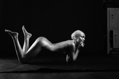 Gümüş rengi vücut boyalı genç atletik kadın.