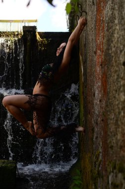 Genç esmer model bir şelale karşı poz