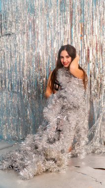 Stüdyoda poz veren parlak noel süsleriyle güzel seksi kadın, tatil konsepti.   