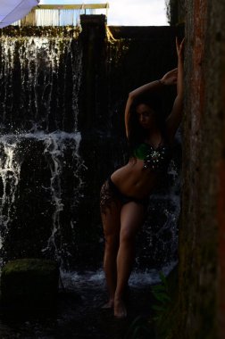 Genç esmer model bir şelale karşı poz