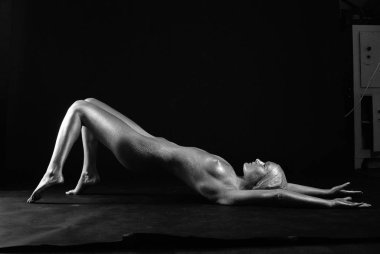 Gümüş rengi vücut boyalı genç atletik kadın.