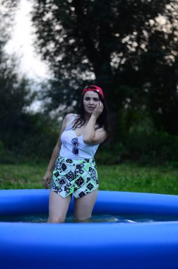 Gün batımında havuzda ıslak, güzel ve büyük bir model..