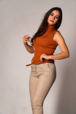 Güzel esmer model, karanlık odada poz veriyor. 