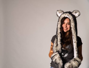 Güzel esmer manken şık kıyafetler içinde, aydınlık odada poz veriyor. 