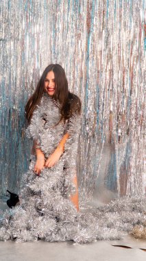 Stüdyoda poz veren parlak noel süsleriyle güzel seksi kadın, tatil konsepti.   