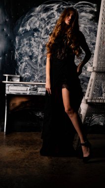 Stüdyoda poz veren narin siyah elbiseli kadın.  