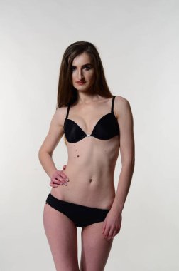 Sarı ceketli, şortlu ve topuklu ayakkabılı zarif bir kadın. Moda stüdyosu çekimi.