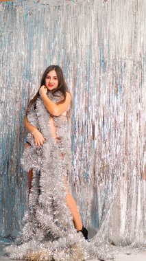 Stüdyoda poz veren parlak noel süsleriyle güzel seksi kadın, tatil konsepti.   