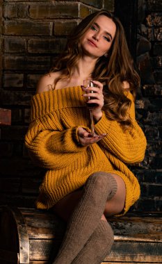 Güzel kız, şöminenin yanında poz veriyor.   