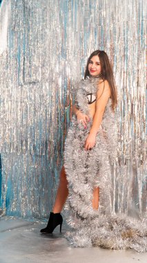 Stüdyoda poz veren parlak noel süsleriyle güzel seksi kadın, tatil konsepti.   