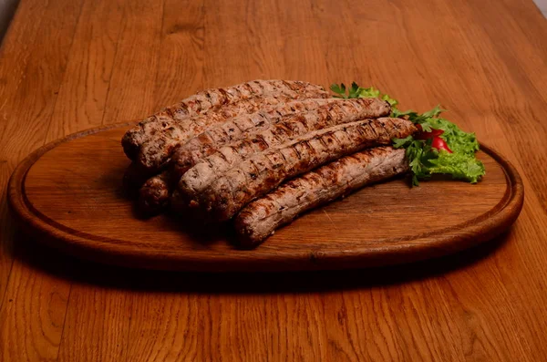 Gustose salsicce grigliate su tavola di legno — Foto Stock
