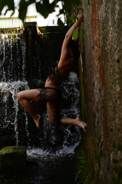 Jovem morena modelo posando contra uma cachoeira — Fotografia de Stock